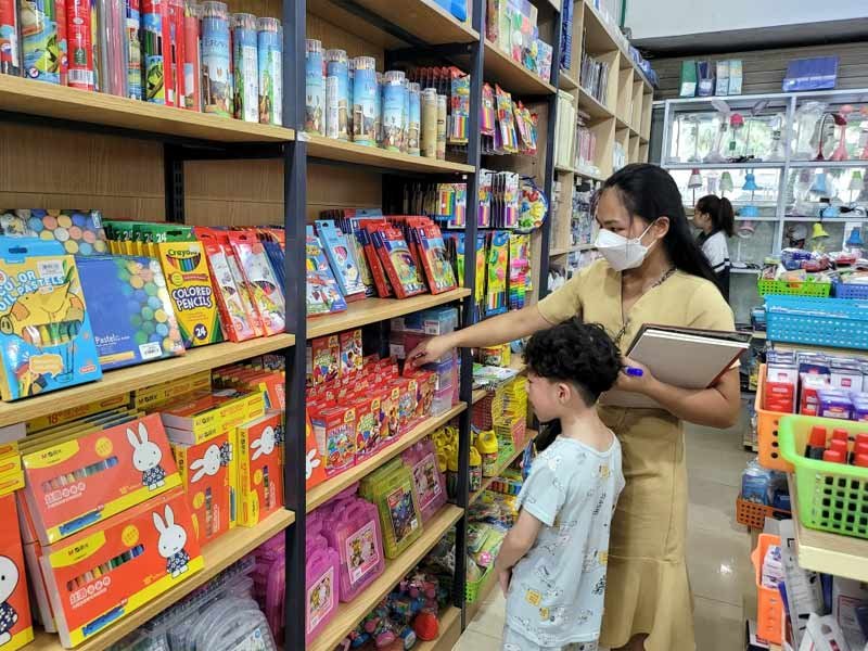 Phụ huynh dẫn con em đi mua đồ dùng học tập tại siêu thị